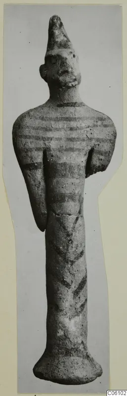 Terracotta figurine of a standing figure with a tall conical head and dark painted bands on the body
