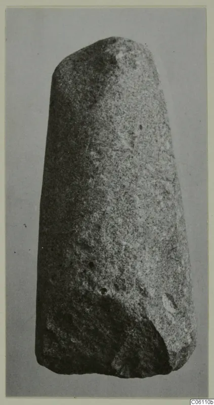 Tapering stone object with a rounded top, photographed against a grey background