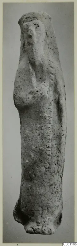 Terracotta statuette of a standing figure, upright, with a rounded head and a pitted, pale surface.