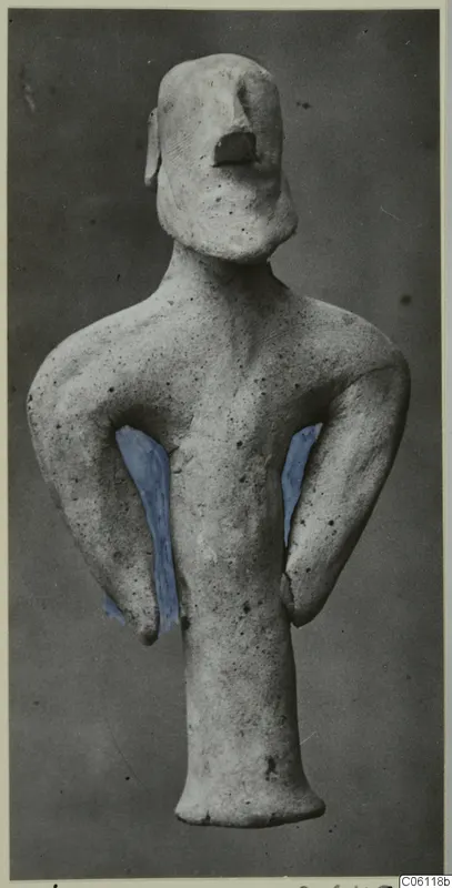 Terracotta statuette of a standing figure with arms bent at its sides, shown against a dark grey backdrop.