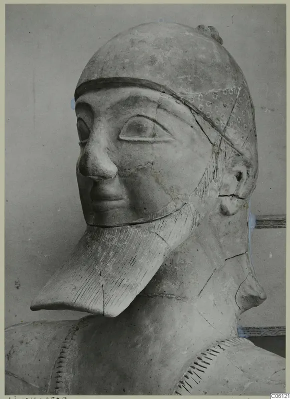 Terracotta statue head and upper body from Ayia Irini, with a close-fitting cap and a long beard with incised lines.