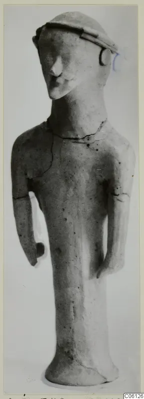 Terracotta statuette of a standing human figure with a flat-topped cap and arms held at its sides, from Ayia Irini
