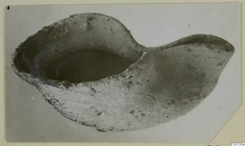 Terracotta lamp from Soli with a deep bowl and a pointed spout to the right, photographed at an angle.