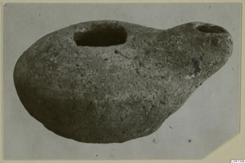 Terracotta lamp from Soli, with a large filling hole and a smaller spout-like opening at one end.