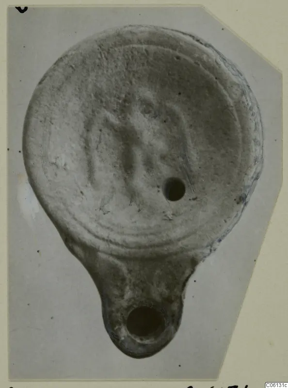 Terracotta lamp from Soli, seen from above, with a central filling hole and a projecting lug with a round opening.