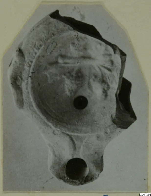 Terracotta oil lamp fragment from Soli, seen from above on a mounted print.