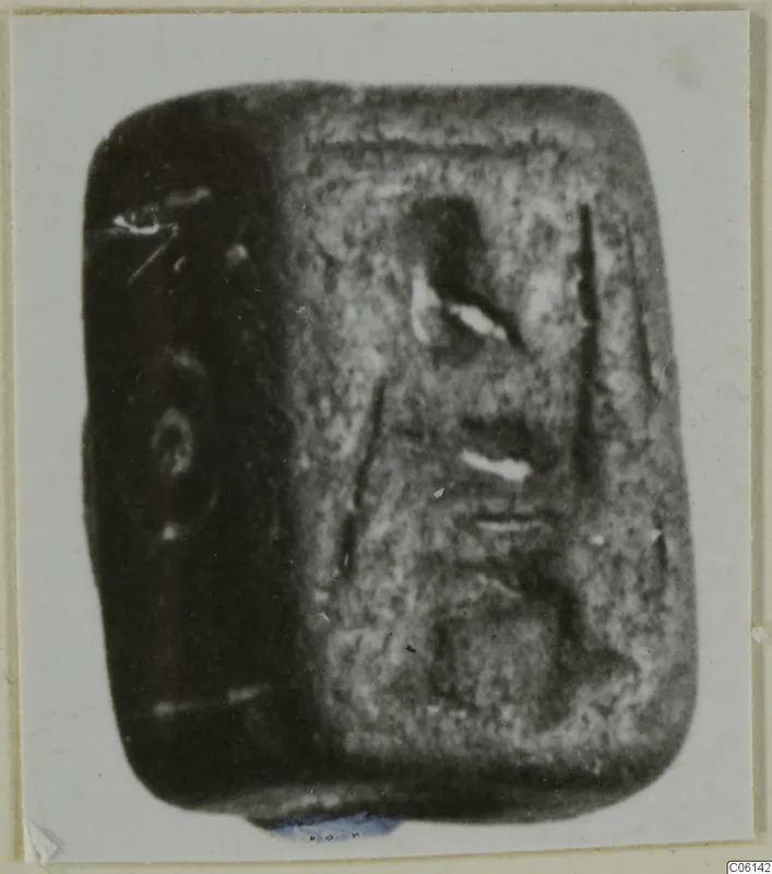 Rectangular stone seal with rounded corners and an engraved face, shown in a photograph on a card mount