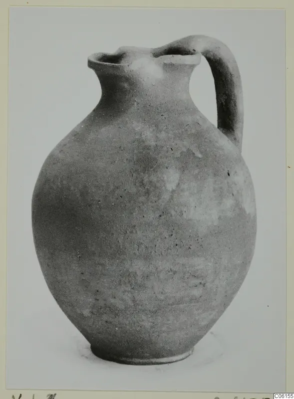 Pottery coarse ware jug with a single handle and a pinched spout.