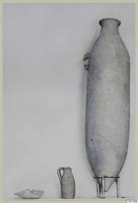 Three pottery objects from Tomb 4 at Vouni: a tall narrow vessel, a small jug and a shallow fragment.