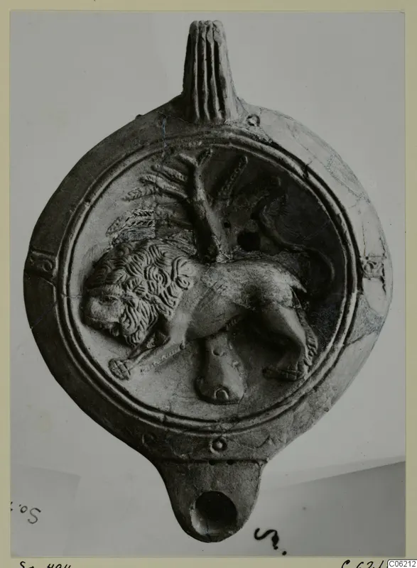 Terracotta lamp with a relief of a lion walking beside a tree or branch on its disc