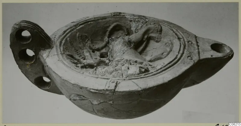 Terracotta oil lamp with a raised relief scene on its disc and a flat pierced handle at the left