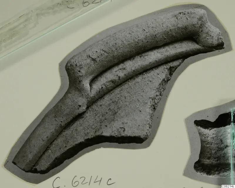 Pottery sherd with a thick curved ridge and a parallel raised band, photographed on a mounted card