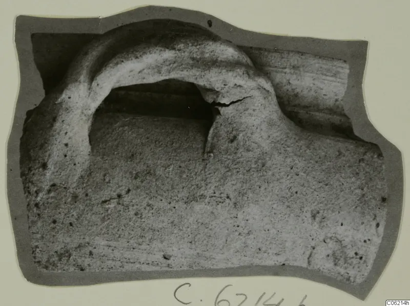 Sherd with a raised arched ridge over a dark recess, shown on a grey card mount