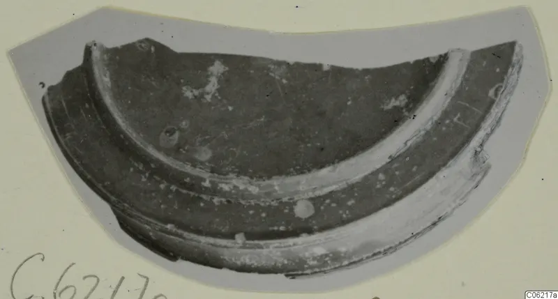 Curved pottery sherd with a raised band running along its outer edge, shown on a grey card mount