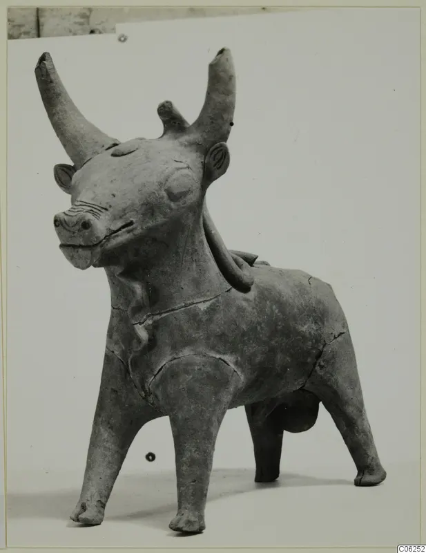 Terracotta figurine of a standing animal with long curved horns and short legs