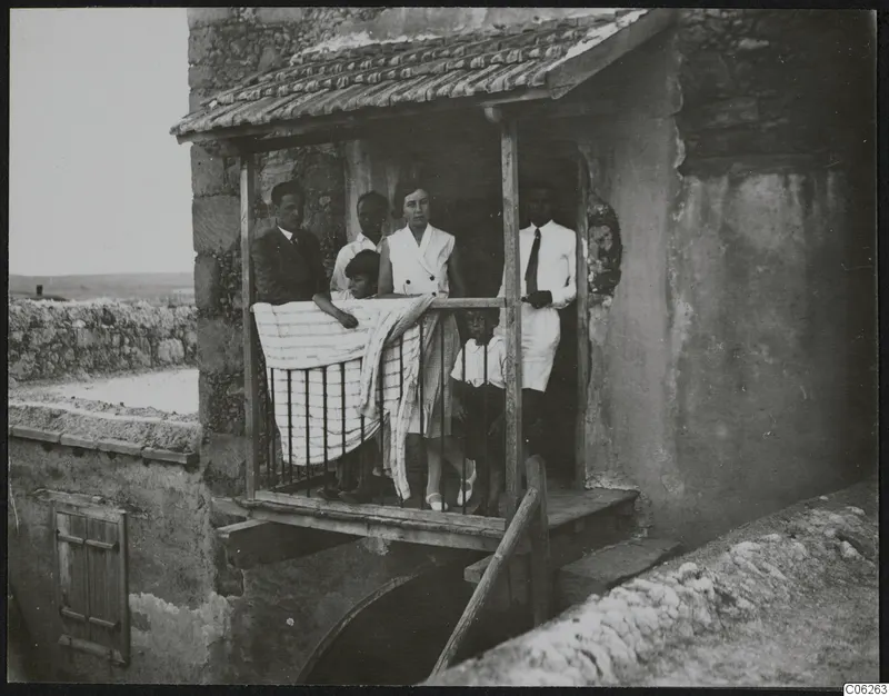The Gjerstad family on a balcony at Ayia Irini, a striped cloth draped over the railing.