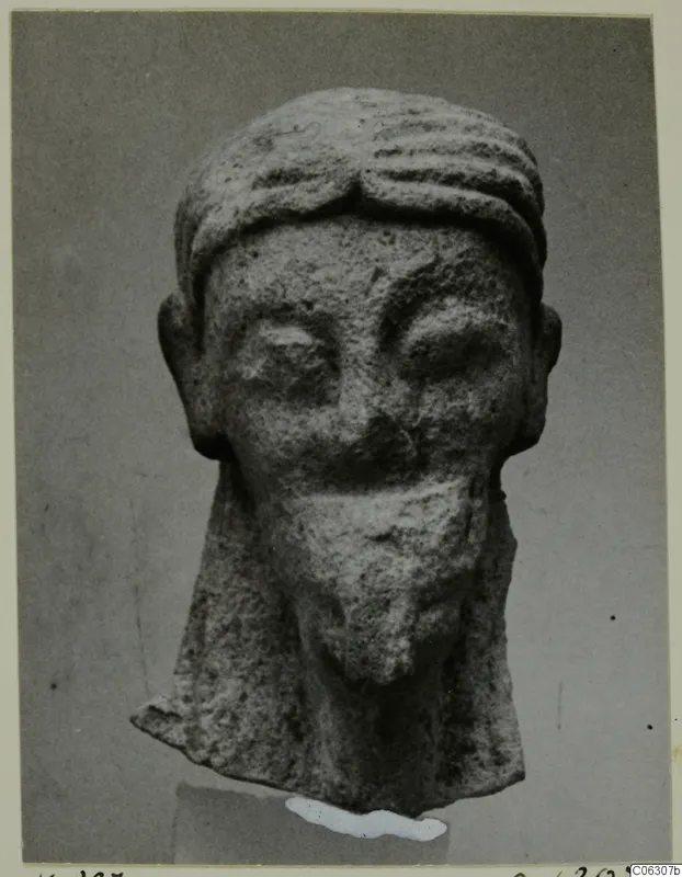 Limestone head of a statue from Kition, front view, with a ridged headband and a square beard