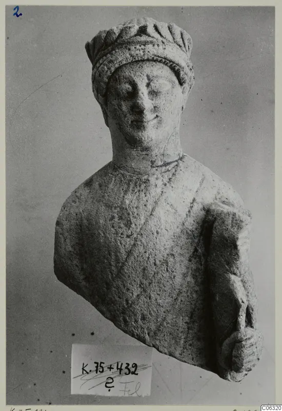 Limestone sculpture of a head and upper body from Kition, wearing a ridged headdress