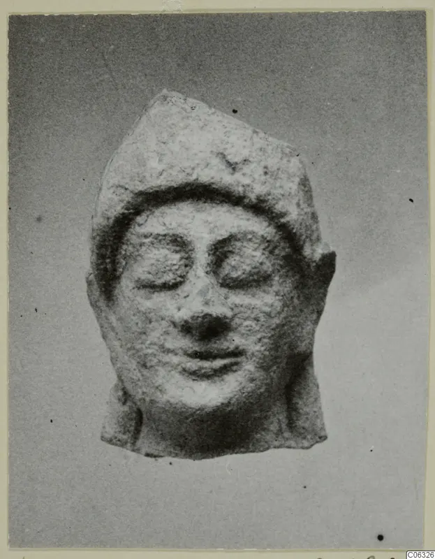 Limestone Neo-Cypriote head with downcast eyes and a cap-like headdress, shown frontally