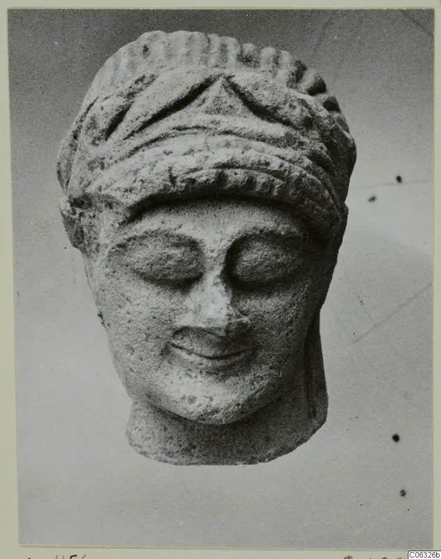 Limestone Cypro-Greek I head fragment from Kition, front view, with closed eyes and a ridged headdress.