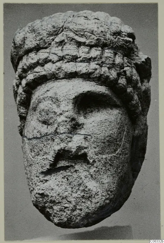 Limestone head sculpture from Vouni, front view against a grey background