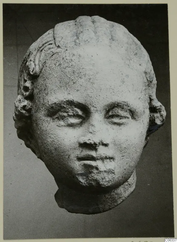Sculpted head from Mersinaki with curled hair above the forehead and ears, and a short neck stump