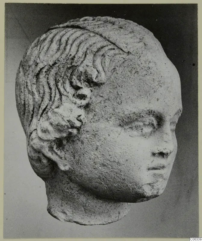 Carved stone head with wavy incised hair and curls above the ear, from Mersinaki.