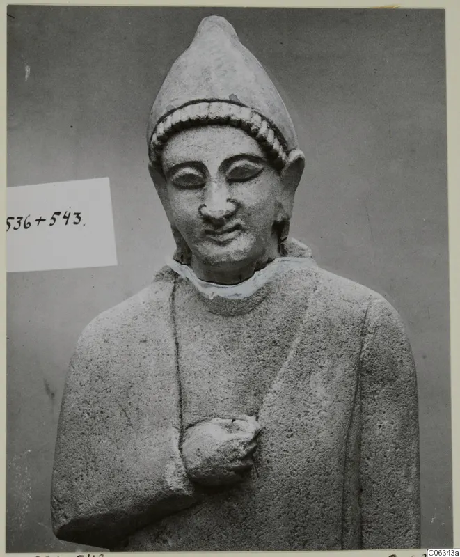 Limestone statue of a head and upper body wearing a tall pointed cap, from Kition