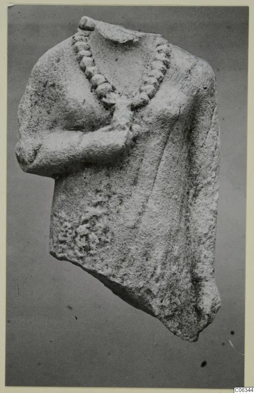 Limestone statue fragment of an upper body with a carved bead necklace and one arm bent across the chest
