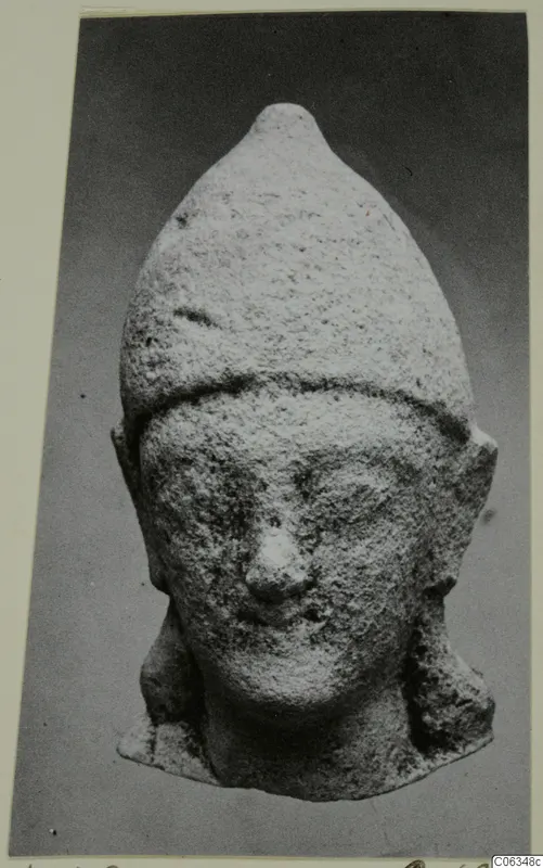 Limestone head of a figure with a tall pointed headdress, from Kition, shown frontally