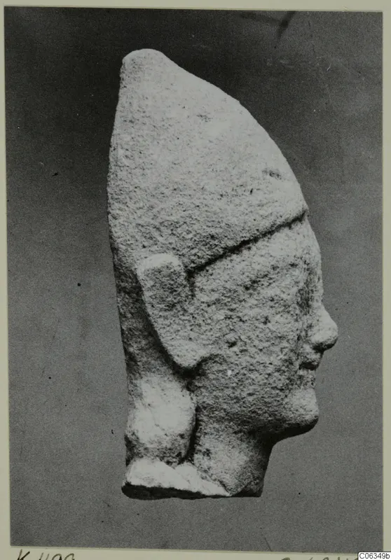 Limestone head statue from Kition, seen in profile facing right, with a tall headdress and a broken flat base.