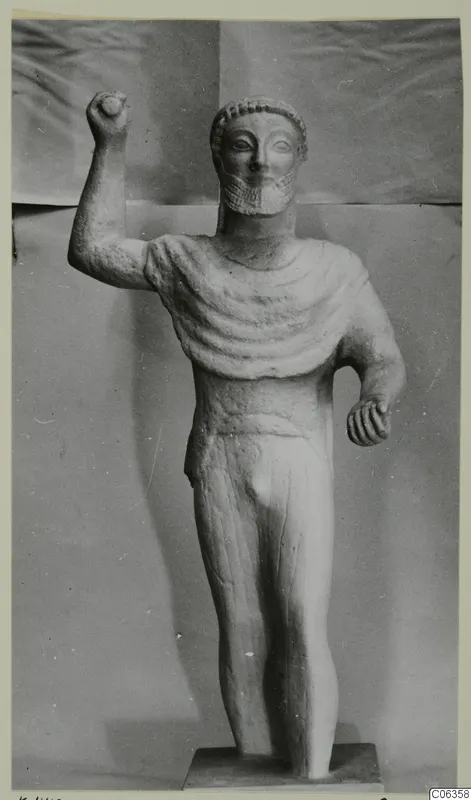 Limestone statue of a standing bearded male figure with one arm raised, from Kition