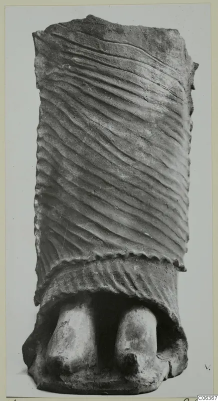 Terracotta object with diagonal grooved surface and two rounded projections at its base