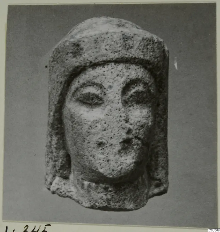 Limestone head from Vouni wearing a close-fitting headdress, with large almond-shaped eyes and a small mouth