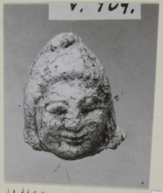 Small limestone head from Vouni with a worn face, almond eyes and a smiling mouth