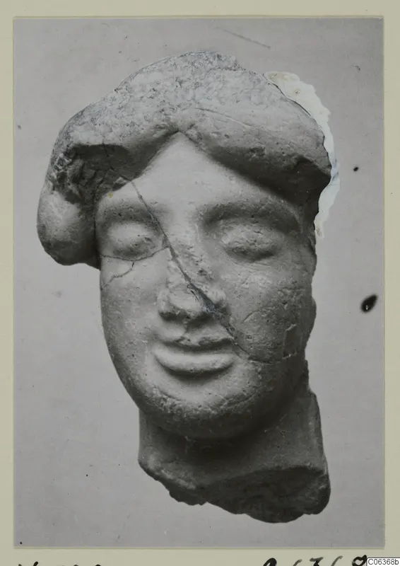Terracotta head of a figure with closed eyes and thick hair, broken at the neck, from Vouni