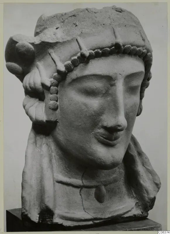 Head and bust of a woman with a bead band across the forehead, sculpture on a dark base