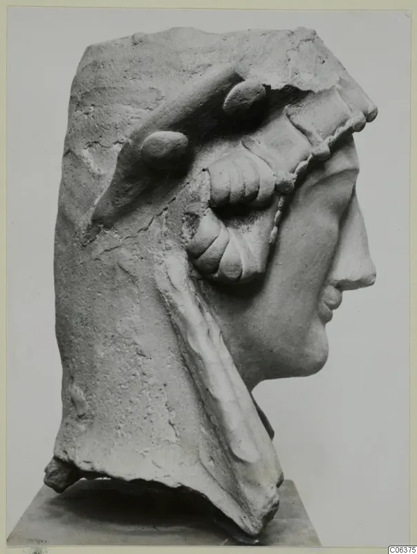 Right profile of a female bust fragment from Vouni, pale and chipped, set on a plinth
