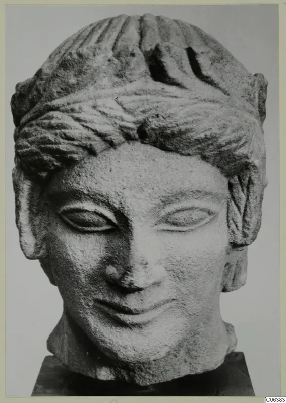 Limestone head from Mersinaki, front view, with bands of combed hair and a slight smile