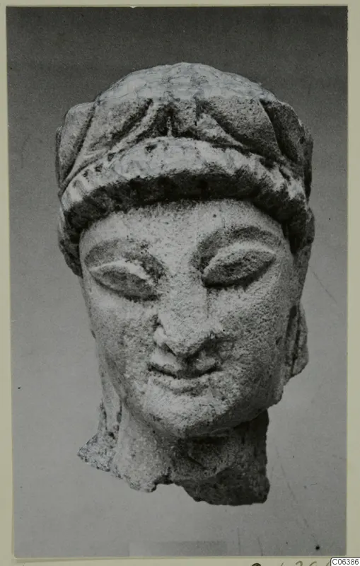 Limestone head from Kition with downcast eyes and a banded headdress, broken off at the neck