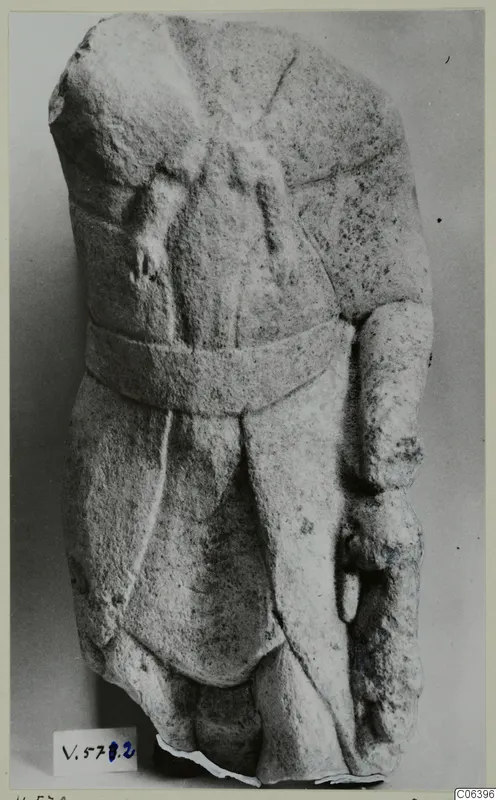 Limestone statuette fragment from Vouni: a torso with a broad belt and drapery folds, head and legs broken away.
