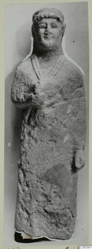 Limestone statue from Vouni of a standing figure in a long garment with hands at the body