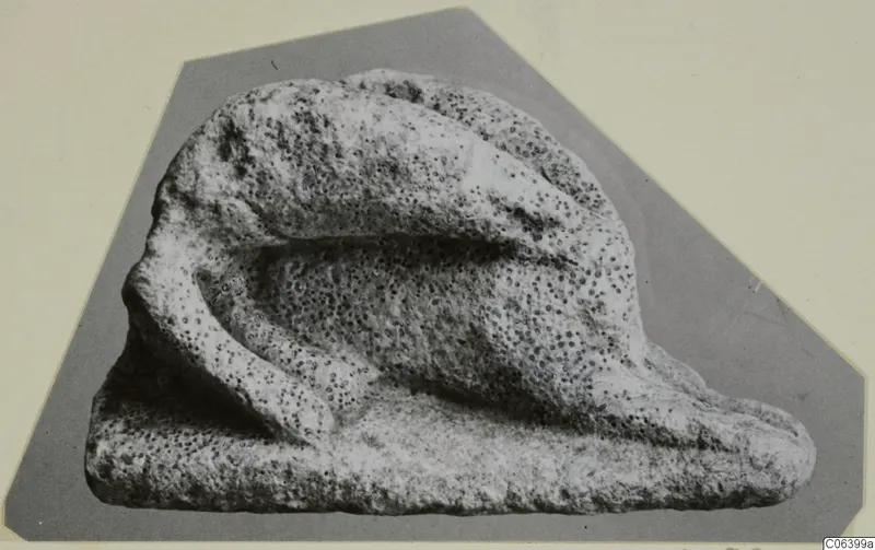 Limestone minor plastic figure, a small pitted stone carving with a curved projection resting on a flat base