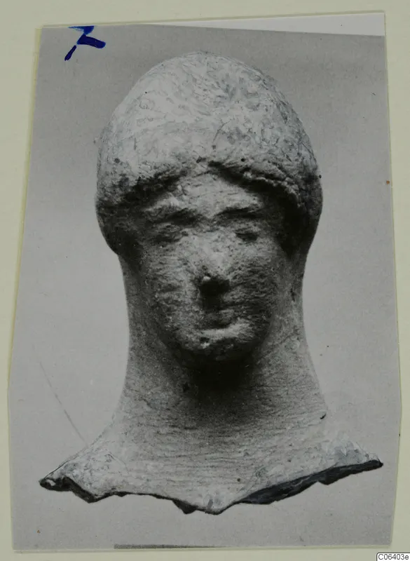 Terracotta head of a figure with a long neck and broken base, photographed on a grey mount