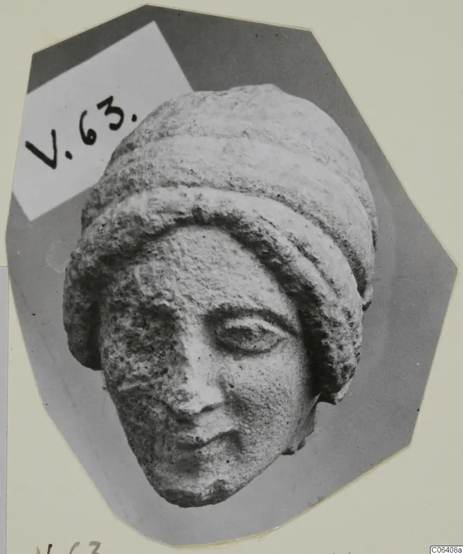 Limestone head fragment from Vouni of a woman wearing a layered headdress, nose chipped