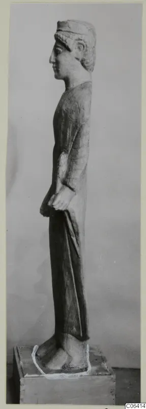 Limestone standing figure in profile, from Vouni, shown on a wooden block base