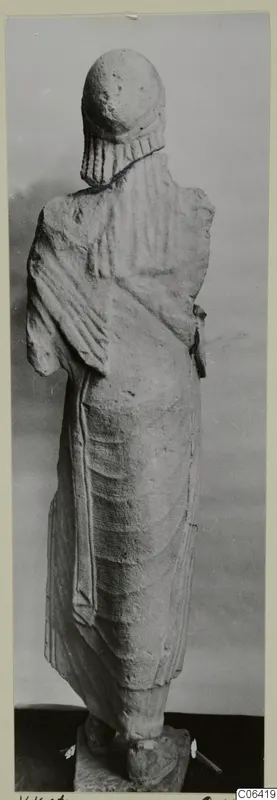 Back view of a limestone statue of a standing figure in a long draped garment, from Vouni