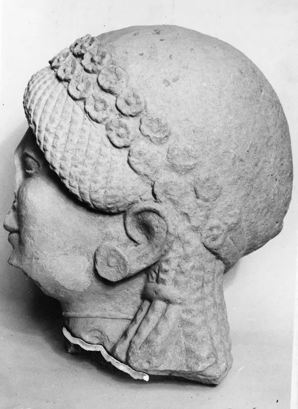 Limestone head in profile facing left, with ridged and curled hair and a large ear, from Vouni