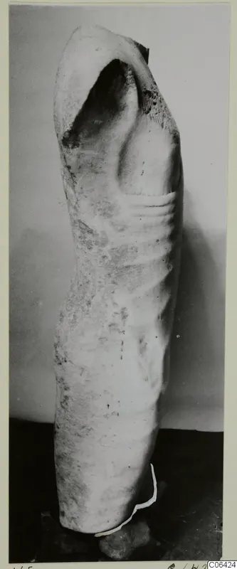Fragmentary limestone sculpture of a figure's torso, broken at the top and base
