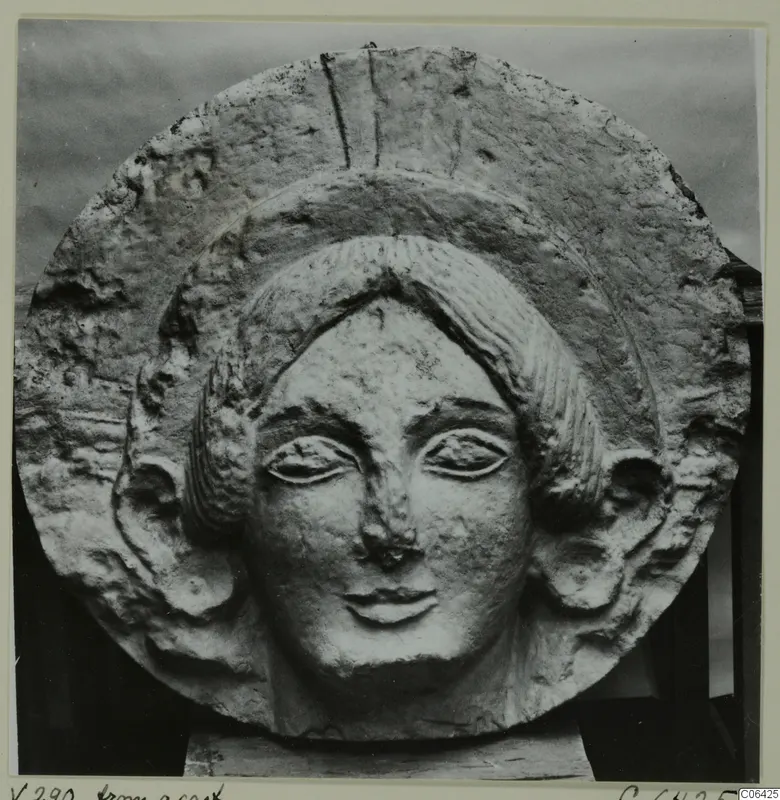 Limestone female head in relief within a round disc, from Vouni